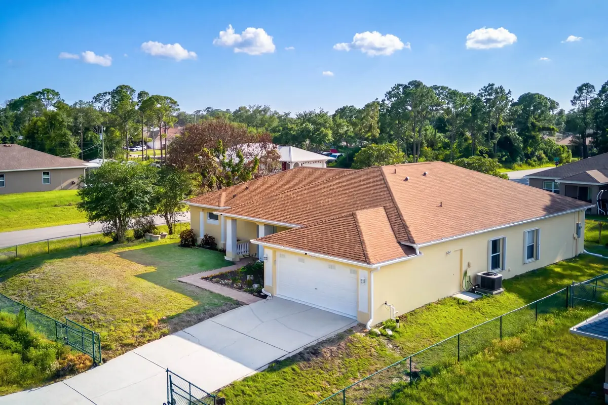 Aerial view of the home with its fenced backyard