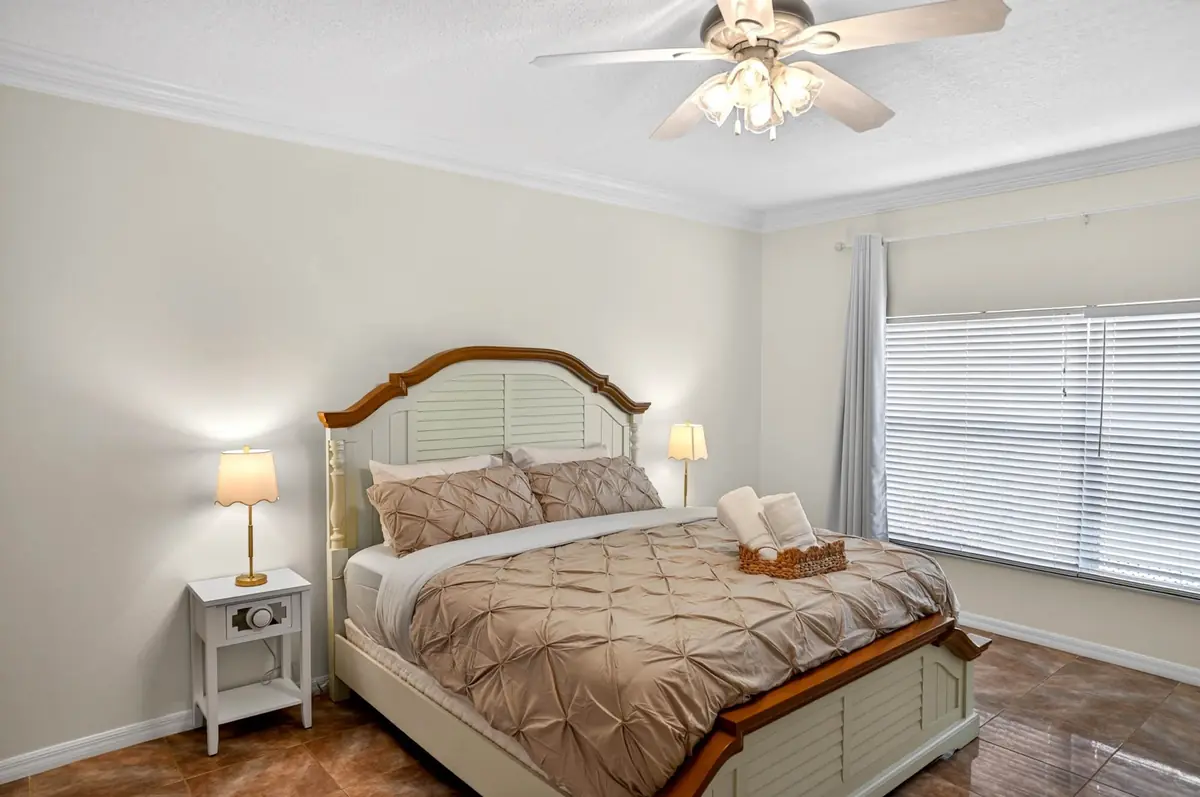 Bedroom with a wood-framed bed and a window with blinds