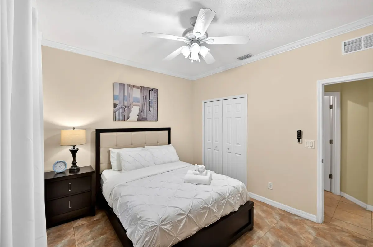 Bedroom with a queen bed, dark headboard and closet