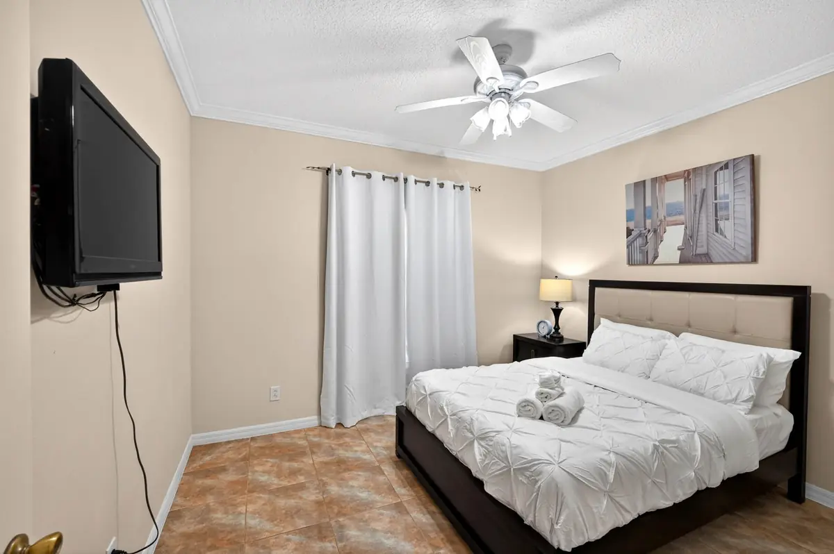 Bedroom with a bed, bedside lamp and wall-mounted TV
