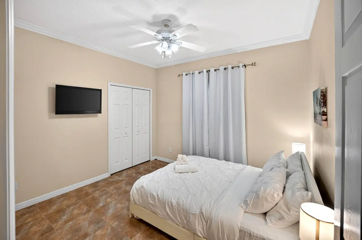 Bedroom with a bed, closet and wall-mounted TV