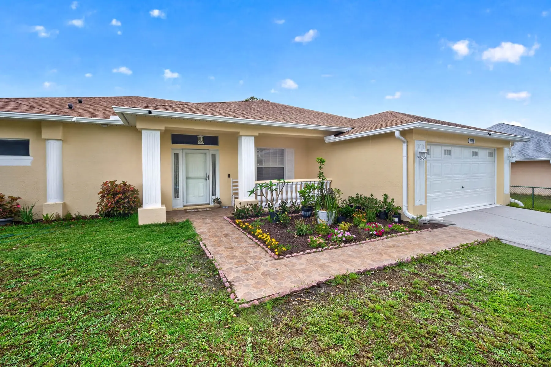 Front of the single-story home with a covered entry and landscaped walkway