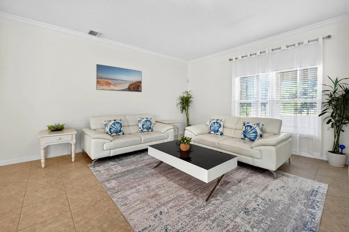 Sitting area with white sofas, blue accent pillows and a large window