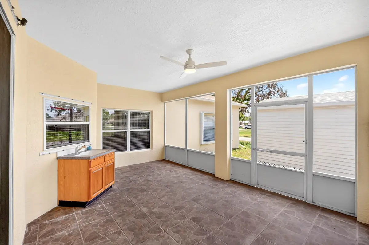 Screened patio with a ceiling fan and a view of the yard